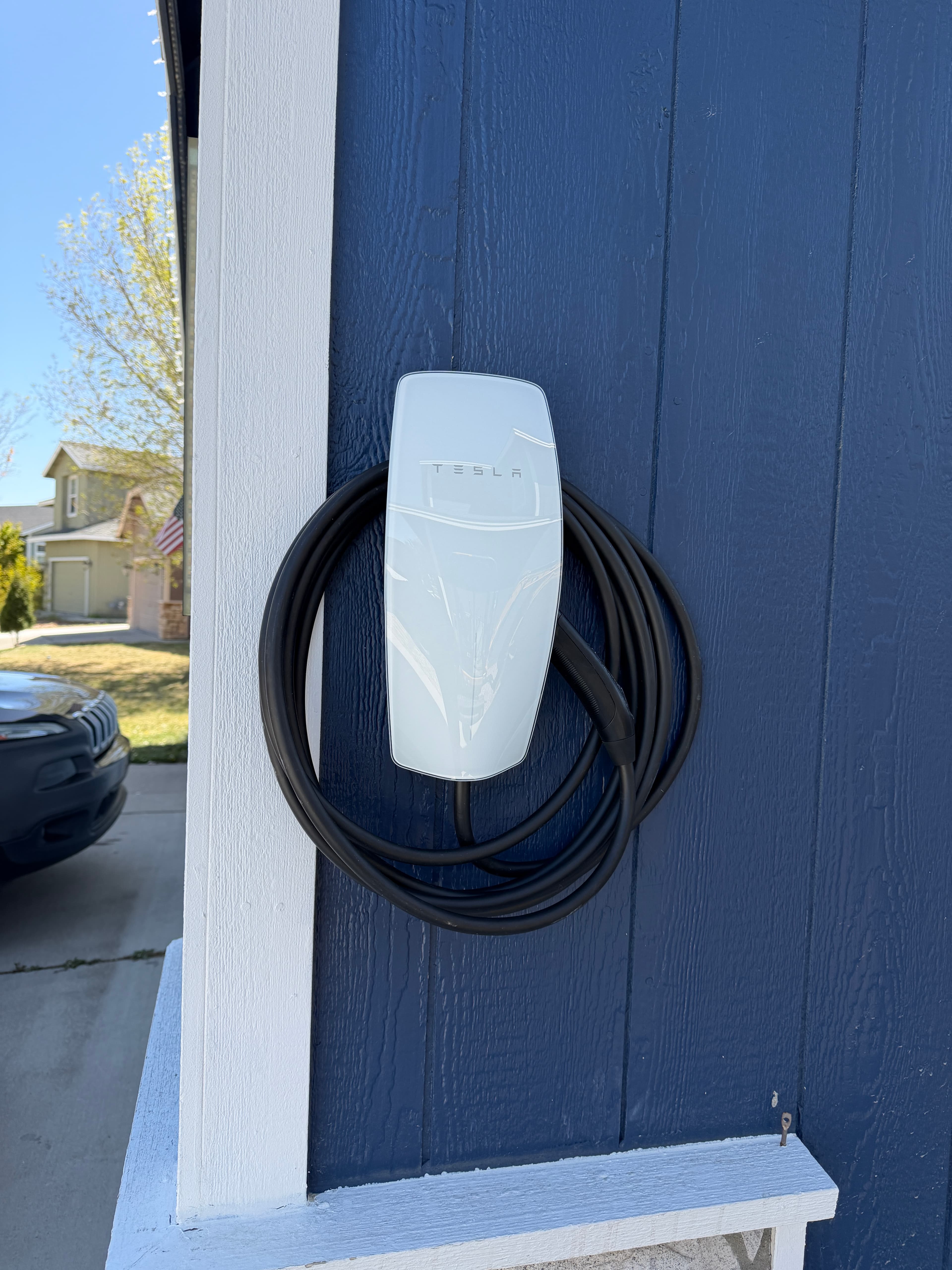 Outdoor Tesla Wall Connector installed on the exterior wall of a Reno garage